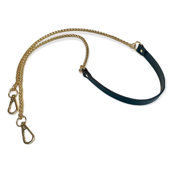 Une bandoulière en chaîne light gold et une partie en cuir couleur marine et deux fermoirs pour pouvoir l'accrocher à tout type de sac.