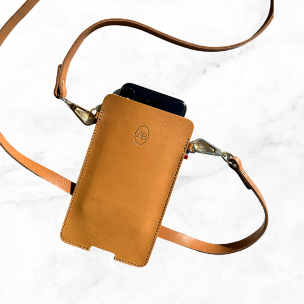 Pochette en cuir pour ranger son portable de couleur marine avec un porte carte à l'arrière. Accrocher de chaque coté par une bandoulière de même couleur.